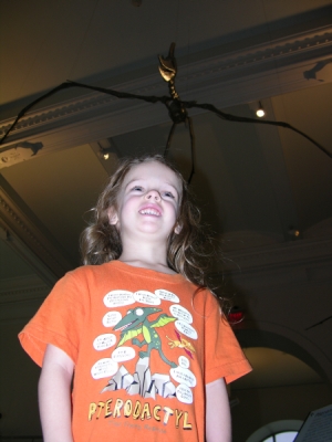 Peo standing under a pterosaur while wearing her pterodactyl shirt.
